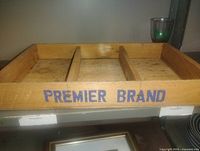 Oblique view of wooden crate showing interior dividers and Premier Brand text