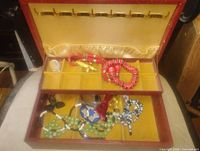 Open jewelry box showing tray and upper compartment with assorted jewelry pieces