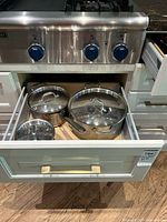 Drawer with three stainless All-Clad pots and lids