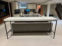 Full frontal view of porcelain top bar table behind sofa