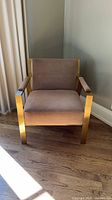 Front view of gold-tone metal frame armchair with taupe upholstery