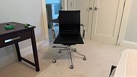 Front view of black ribbed desk chair with chrome arms and base