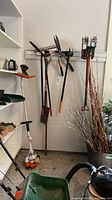 Overview of wall-mounted garden tools and Stihl trimmer