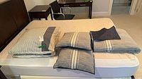 Overview of all pillows on mattress with folded bedspread