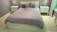 Front view of assembled white queen bed with lavender bedding