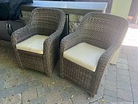 Front view of two matching wicker chairs with cushions