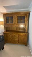 Full view of oak hutch showing upper glass doors, drawers, open shelf, and lower cabinet