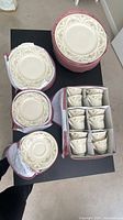 Three padded storage cases opened to show stacks of saucers and separated teacups