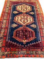 Full view of Persian wool rug showing field, medallions and borders