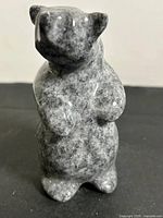 Front view of grey speckled stone bear carving