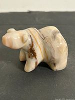 Front angled view of polished marble bear figurine showing cream color and veining