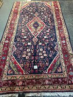Full view of handmade Persian wool rug showing pattern, colors, and scale