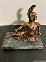 Full view of Achilles bronze-tone statue mounted on grey marble slab