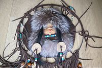 Close view showing doll face, fox fur, beads, leather fringe