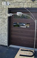 Full view of assembled arch floor lamp beside garage door