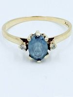 Front view of ring showing blue topaz and accent stones