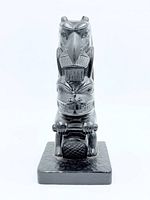 Front view of black stone totem carving on base