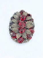 Front view of brooch showing red stones and leaf motif