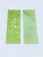 Front view of both light green carved jade plaques