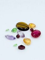 Top-down view of assorted loose gemstones on white background