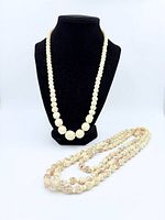Both carved bone bead necklaces displayed, showing size difference