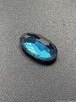 Close-up of oval faceted blue topaz gemstone