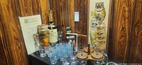 Overall lot view showing glasses, condiment set, owl plaque, empty bottles