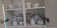 Cabinet view showing both Noritake sets, Royal Standard pieces, cups, saucers and trivet