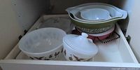 Cabinet drawer showing multiple Pyrex bowls and Corning Ware casserole