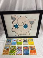 Framed Jigglypuff art with cards laid out