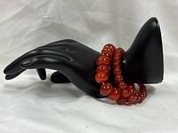Two carnelian beaded bracelets displayed on mannequin hand