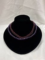 Three bead strand necklaces displayed on bust
