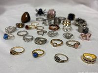 Group view of entire lot of assorted rings on white backdrop