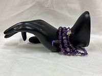 All three amethyst bracelets displayed on black hand form