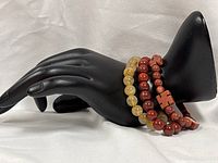 Three beaded stretch bracelets on black display hand