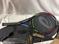 Asics BZ 100 racquet resting on matching case