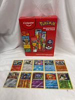 Front view of sealed Colgate Pokémon gift pack with ten holographic cards laid out