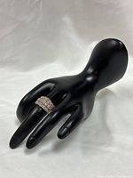 Full view of sterling silver cluster diamond ring on display hand