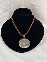 Full necklace displayed on black bust showing pendant shape and leather cord