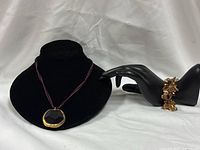 Necklace displayed on bust and bracelet on mannequin hand