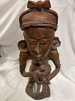 Full view of statue front showing headband, facial features, staff