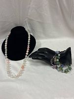 Overview of necklace on bust and bracelets on hand display