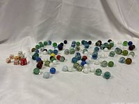 Wide view of entire lot showing marbles spread out and dice grouped to left