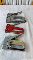 Three staple guns laid out showing overall condition and finishes