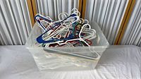Bin filled with assorted white and coloured plastic hangers