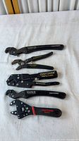 Five Craftsman adjustable pliers and wrench laid out on white cloth