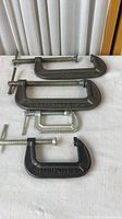 All four C-clamps laid out showing size and markings