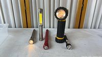 All five flashlights standing upright on table