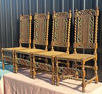 Four carved walnut William and Mary chairs side by side showing overall design