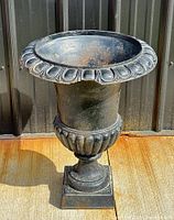 Full view of cast iron urn showing shape, design and base